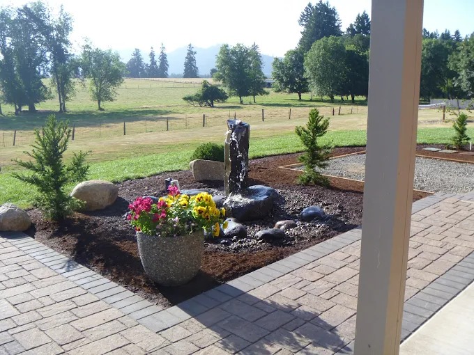 Basalt column bubbler fountain in a river rock planting bed