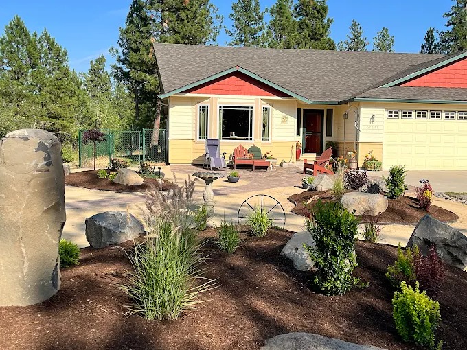 Drought-tolerant front yard with basalt column, boulders, and bark mulch